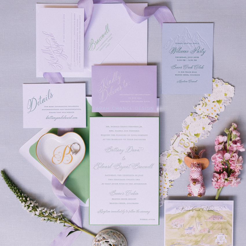 Wedding invitation set with floral decorations on a light gray background